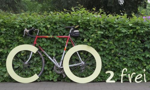 Ein Rennrad formt mit sein Reifen ein CO2-Logo