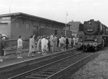 Historische Szene: Menschen auf dem Bahnsteig in Waldniel steigen in einen Zug 
