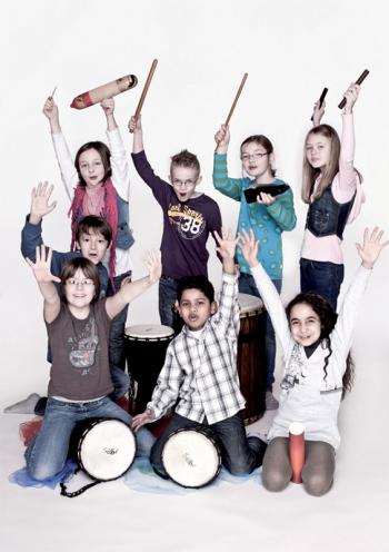 Kinder mit Instrumenten recken freudig die Arme in die Höhe