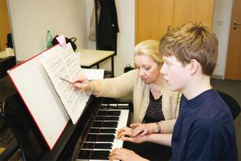 Klavierlehrerin unterrichtet Jugendlichen