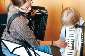 Musikschüler mit seiner Lehrerin beim Akkordeonunterricht