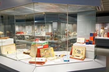 hell erleuchtete Museums-Vitrinen mit historischem Spielzeug