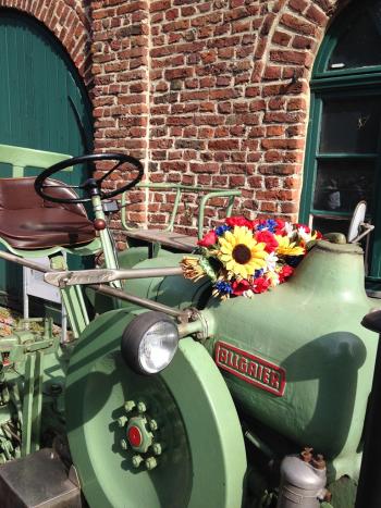 Blumendekorierter Traktor vor einer Scheune