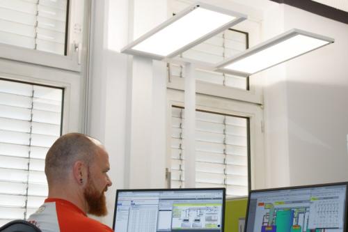 Zwei moderne LED-Lampen über einem Arbeitsplatz mit Computer